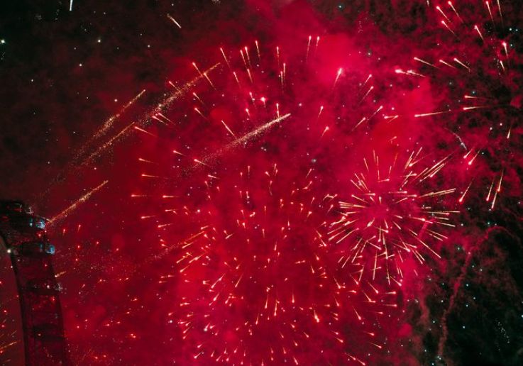 Red New Year's Eve fireworks beside the London Eye at midnight