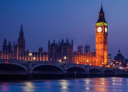 Big Ben and the Houses of Parliament lit up at dusk, with Westminster Bridge over the Thames