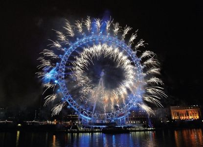 Blue and white fireworks bursting around the London Eye at night