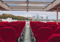Rows of red seats under the glass roof of the Silver Raven, with St Paul’s Cathedral and the City of London skyline across the Thames