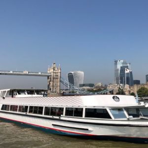 The Silver Sockeye, a white Thames cruise boat, in front of Tower Bridge by day