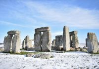 Stonehenge sous la neige dans la plaine de Salisbury, vu depuis la route le jour de Noël