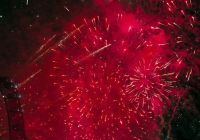 Red New Year's Eve fireworks beside the London Eye at midnight