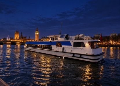 Thames cruise boat at night in front of the lit-up Big Ben and Houses of Parliament