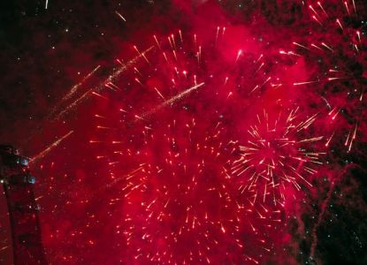 Red New Year's Eve fireworks beside the London Eye at midnight