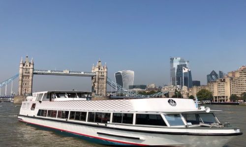 El Silver Sockeye, un barco de crucero blanco, en el Támesis delante del Tower Bridge, de día
