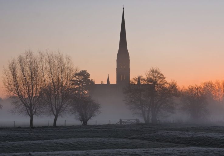 La flèche de la cathédrale de Salisbury au-dessus de la brume d'hiver, à l'aube